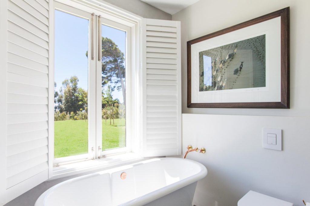 White plantation shutters fitted to a large interior window